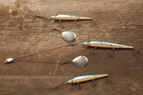 five metal fishing lures, two of which have no hooks