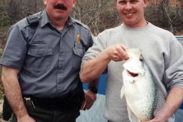 Samuel Barbee and his state record white crappie next to a conservation agent
