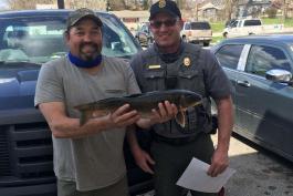 Harvey Smith holding white sucker with Conservation Agent Jeff Harris.