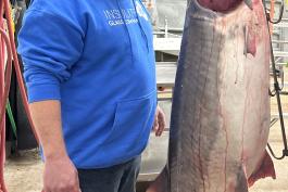 Chad Williams stands next to world record 164-pound, 13-ounce paddlefish