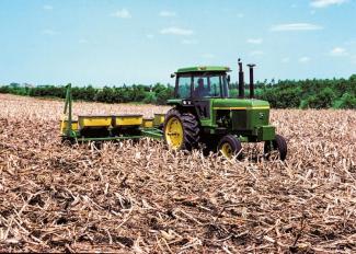 Tractor in field with cornstalk remnants
